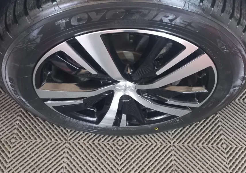 Gros plan sur la jante alliage bicolore noir et argent d’un Peugeot 3008 gris clair, pneu Toyo visible.