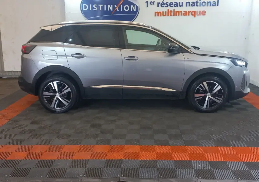 Vue de profil côté gauche d'un Peugeot 3008 GT gris clair 2022 avec jantes alliage et toit noir contrasté.