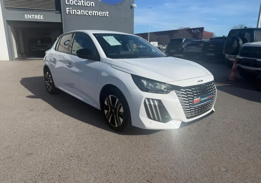 Peugeot 208 Hybrid blanc vue 3/4 avant droit, calandre distinctive et jantes alliage bicolores visibles.