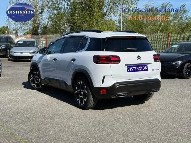 Vue 3/4 arrière droite du Citroën C5 Aircross blanc Okénite avec toit noir et jantes distinctives en alliage.