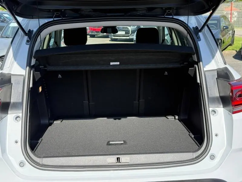 Coffre ouvert vu de l'arrière d'un Citroën C5 Aircross blanc Okénite 2025, montrant l'espace de chargement vide.