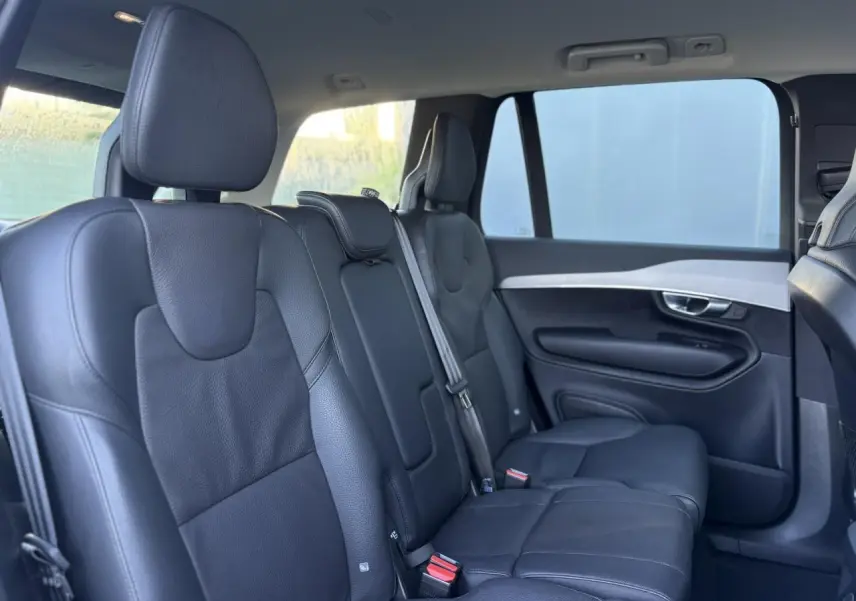 Vue intérieure côté droit des sièges arrière en cuir noir du Volvo XC90 T8 AWD 2024, ambiance lumineuse naturelle.