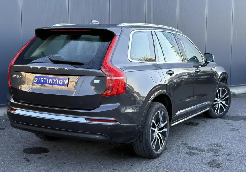 Vue 3/4 arrière droite d'un Volvo XC90 gris Platinium avec jantes alliage et feux arrière LED distinctifs.