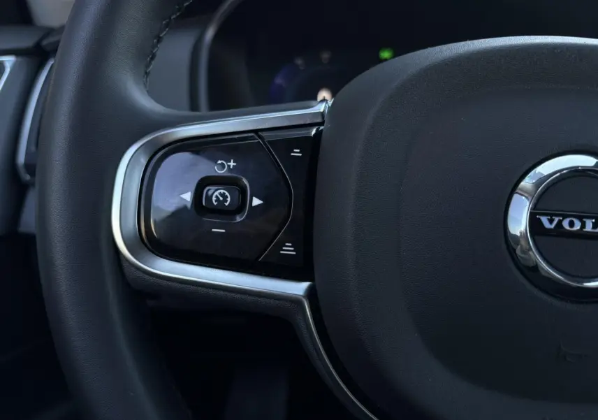 Gros plan sur la partie gauche du volant noir du Volvo XC90 T8 avec commandes de régulateur de vitesse intégrées.