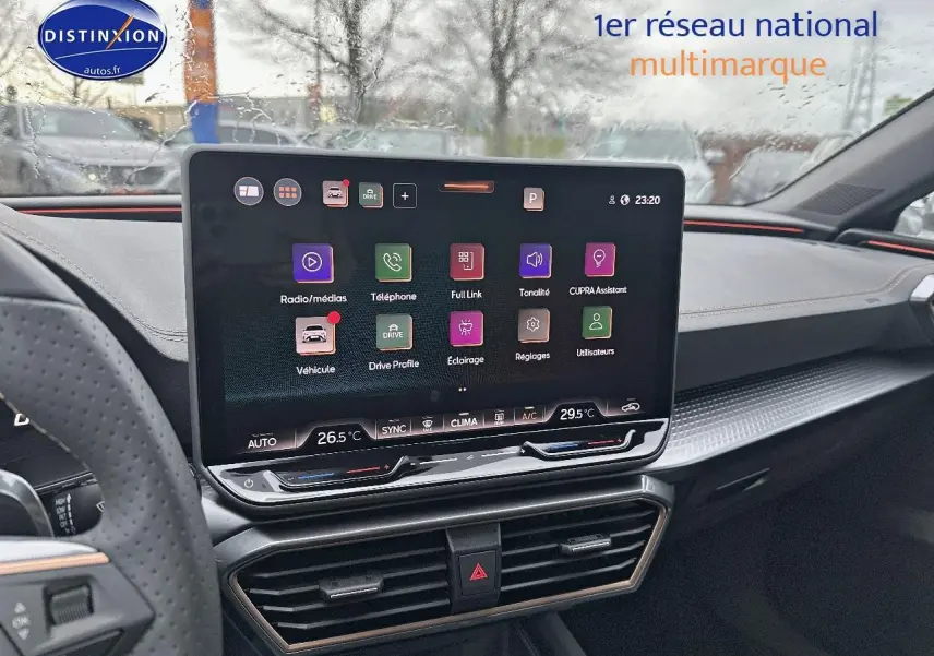 Vue intérieure de face du tableau de bord de la CUPRA Leon ST 1.5 etsi hybrid gris magnétique avec écran tactile central allumé.