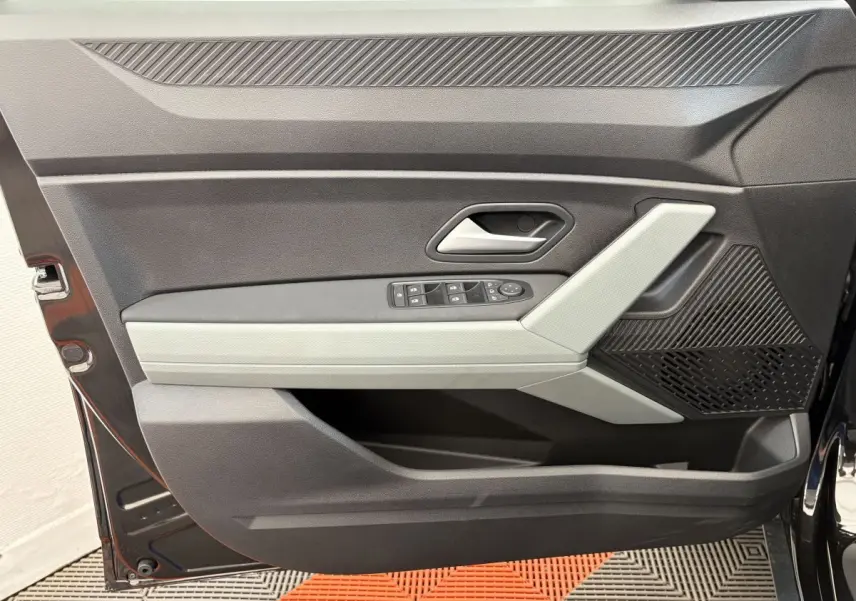 Porte côté gauche ouverte du Dacia Duster noir 2025, montrant les commandes de vitres et le design intérieur moderne.