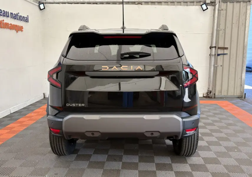 Vue arrière du Dacia Duster noir 2025, soulignant ses feux LED et son pare-chocs arrière gris robuste.