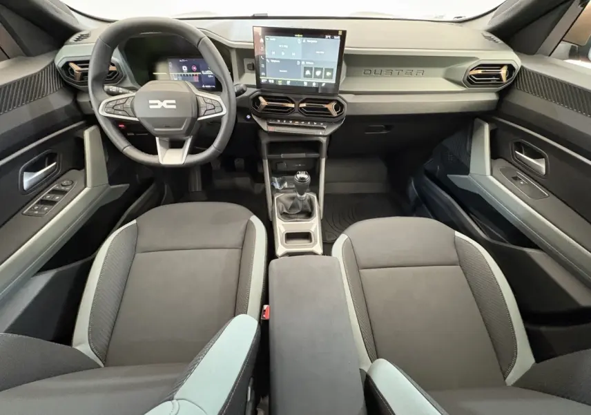 Intérieur du Dacia Duster 2025 noir, vue avant centrée sur le volant, tableau de bord et écran tactile.