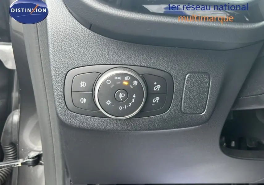 Gros plan sur le bouton de réglage des phares du Ford Puma gris magnétique, intérieur côté gauche.