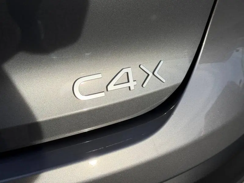 Gros plan sur l’inscription C4 X en relief sur la carrosserie gris Mercury d’une Citroën 2025.