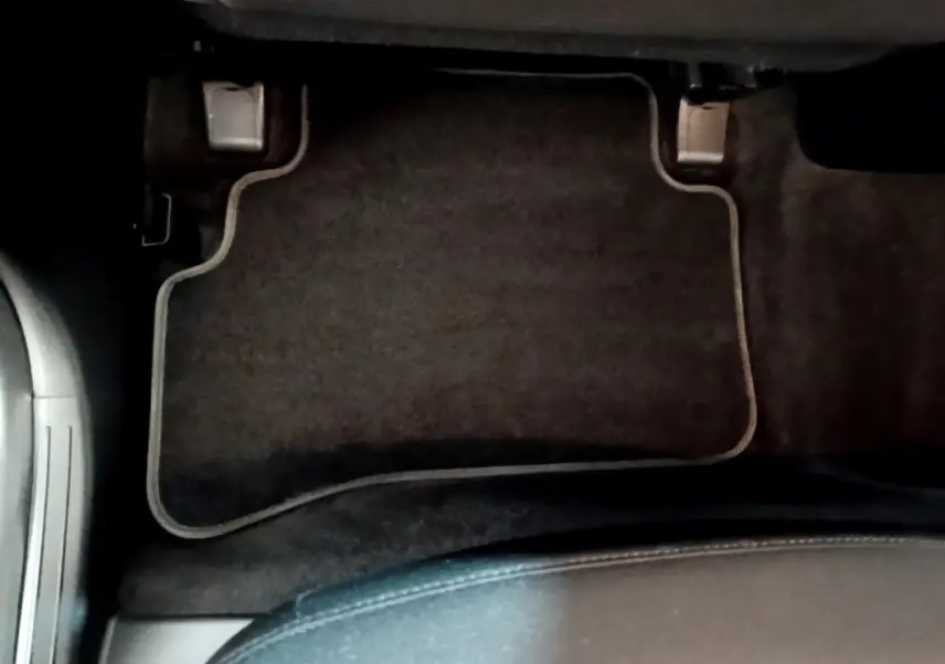 Vue plongeante sur le tapis de sol noir côté conducteur du Hyundai Tucson gris foncé 2022 hybride rechargeable.