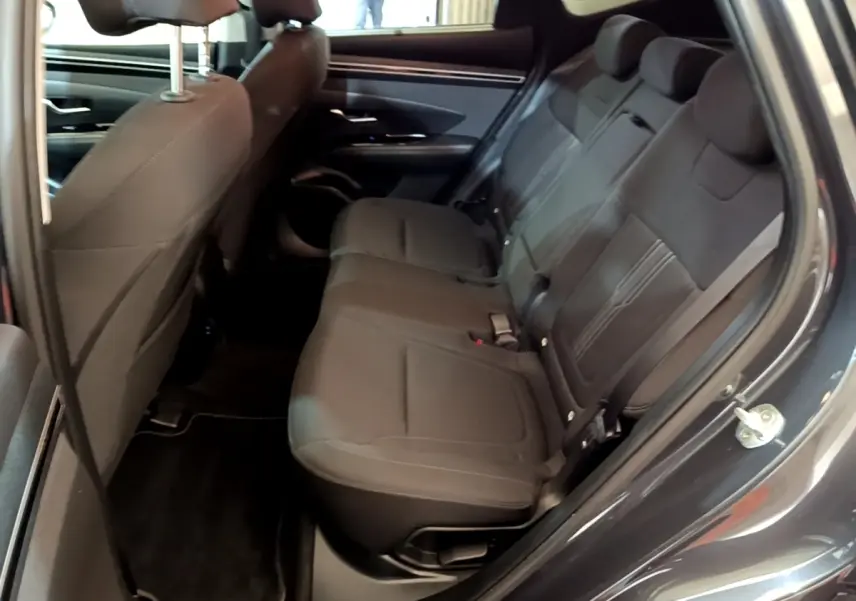 Vue intérieure côté droit des sièges arrière noirs du Hyundai Tucson 2022 gris foncé, avec ceinture de sécurité visible.