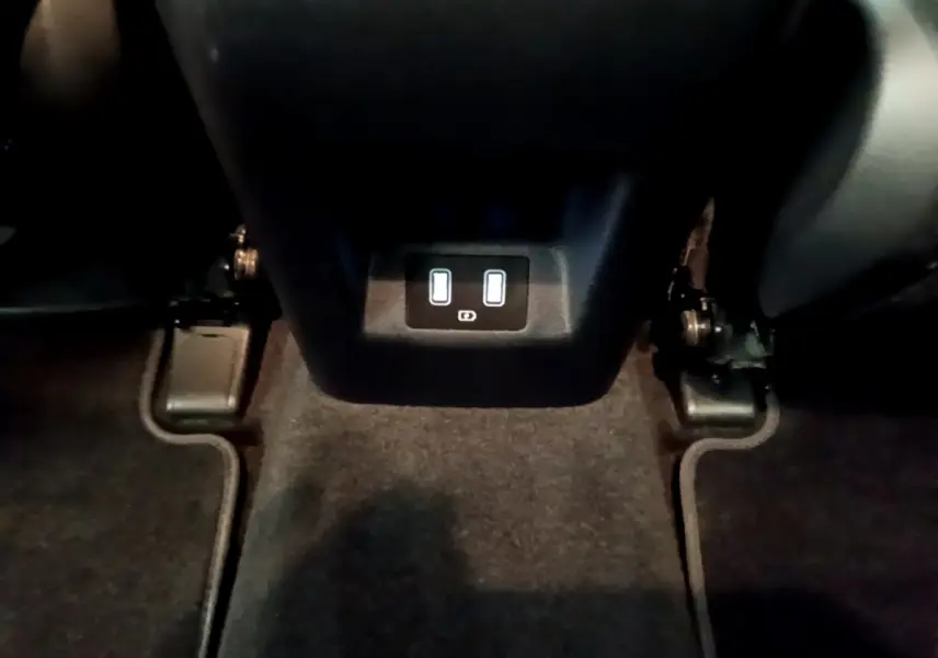 Prise USB double arrière sur console centrale noire du Hyundai Tucson gris foncé 2022, vue intérieure basique.