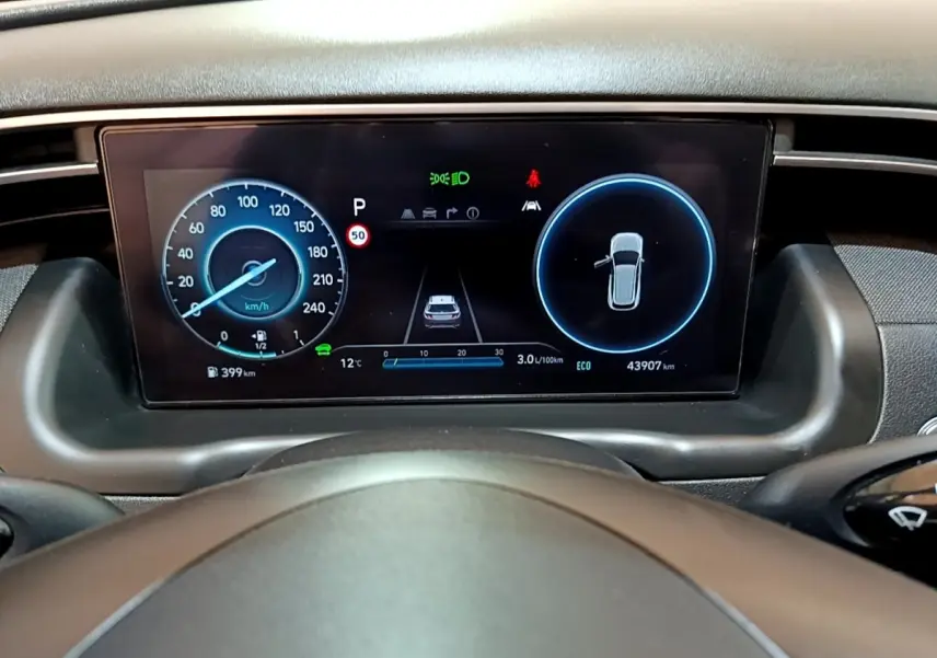Tableau de bord numérique du Hyundai Tucson 2022, affichage vitesse et alertes, vue depuis le volant.