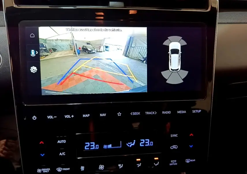 Écran tactile central affichant la caméra de recul avec guidage et capteurs de stationnement du Hyundai Tucson gris foncé.