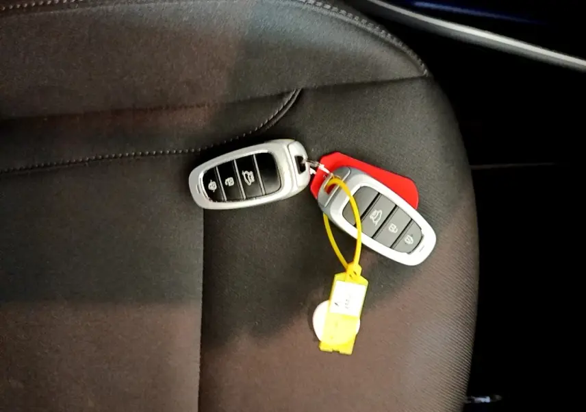 Gros plan sur deux clés de voiture Hyundai posées sur un siège tissu noir, sans vue du véhicule.