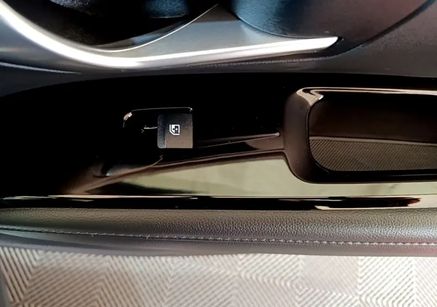 Détail de la commande d'ouverture du coffre sur la porte côté conducteur du Hyundai Tucson gris foncé 2022.