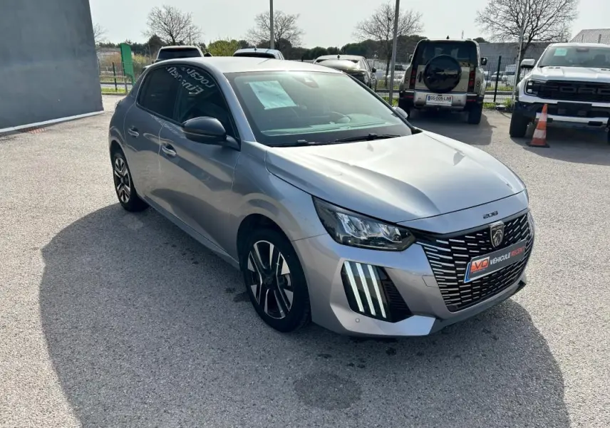 Peugeot 208 Hybrid gris vue 3/4 avant droit, avec calandre distinctive et feux LED verticaux marquants.