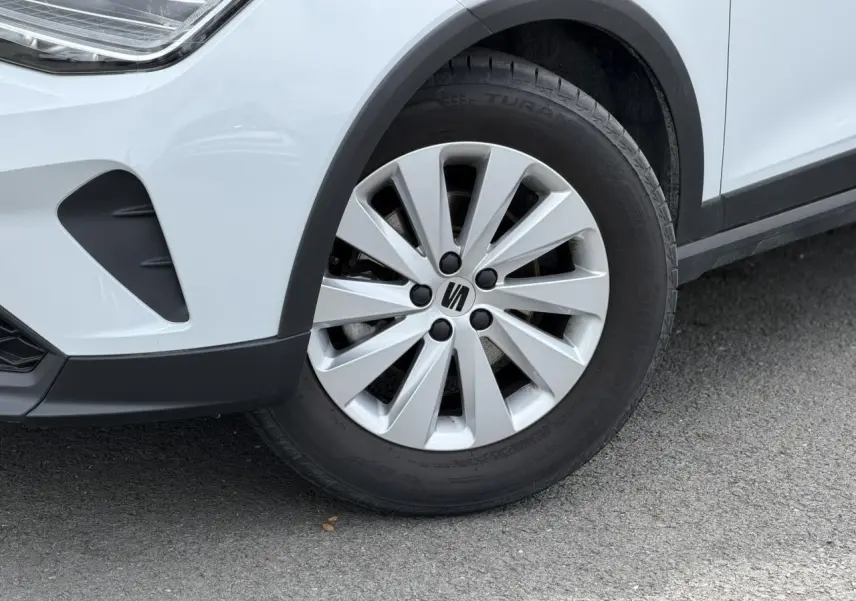 Gros plan sur la roue avant droite d’un SEAT Arona blanc alpin avec jante alliage 16 pouces design.