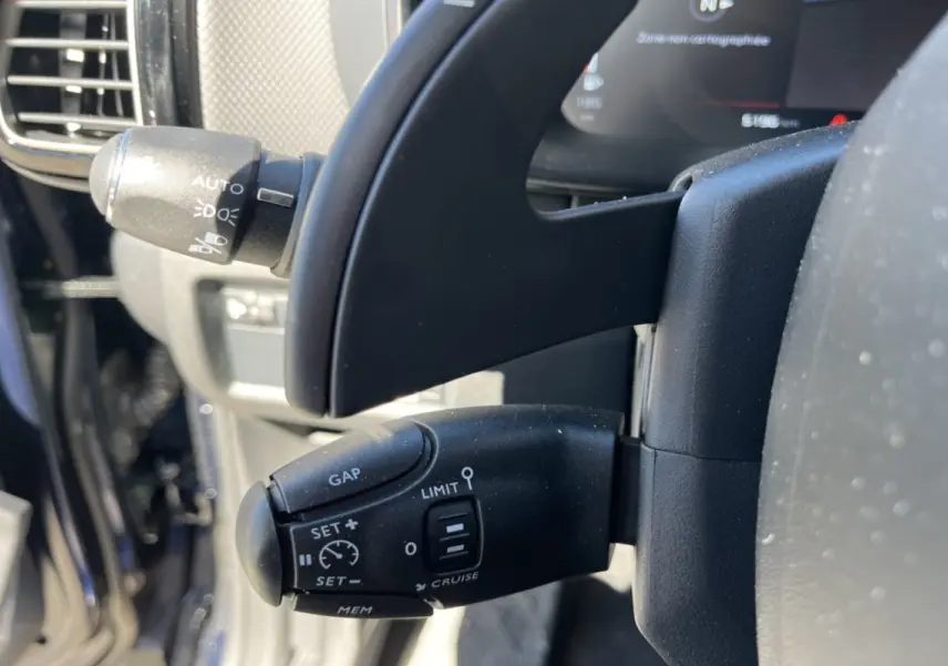 Gros plan sur la commande de régulateur de vitesse au volant d’un Citroën C5 Aircross Bleu Eclipse 2025.