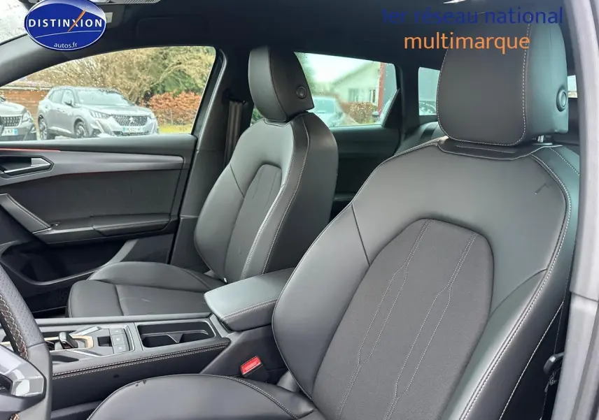 Vue intérieure côté avant droit de la CUPRA LEON ST 2025 avec sièges cuir gris et accoudoir central.