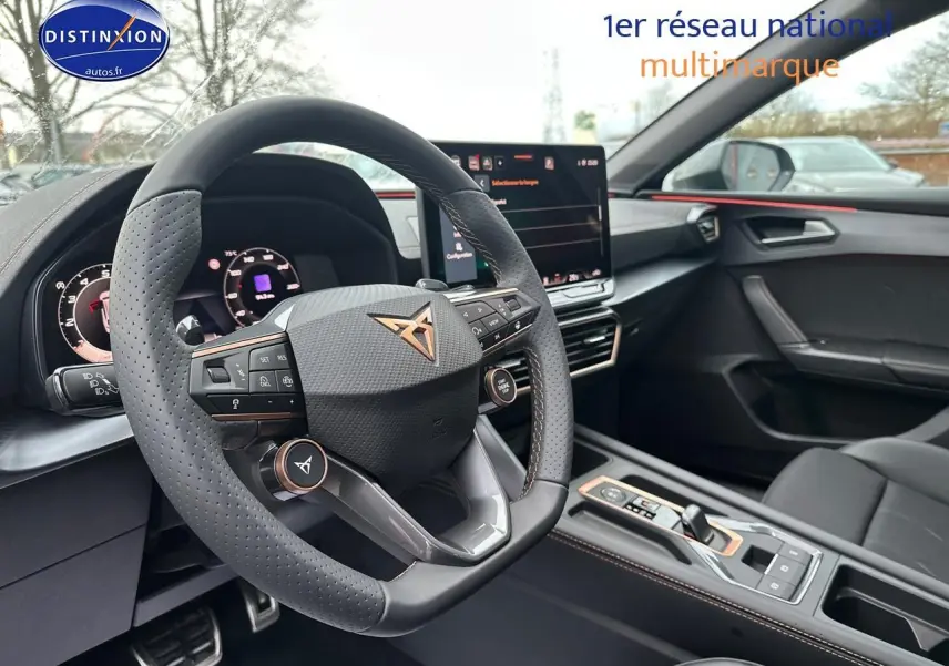 Intérieur de la CUPRA LEON ST 2025 vu côté conducteur, volant cuir perforé et écran tactile central.