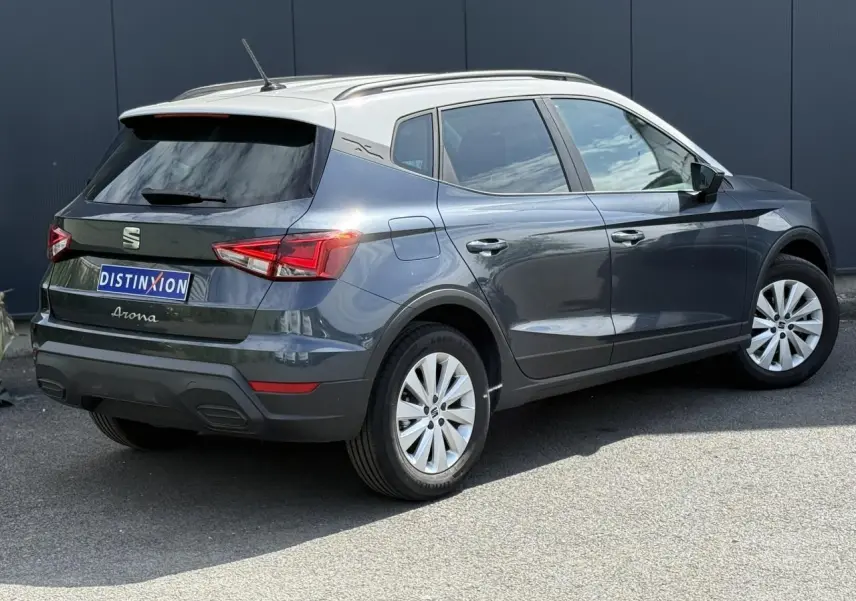 Vue 3/4 arrière droite d'un SEAT Arona 2025 gris magnétique avec toit blanc et jantes alliage 16 pouces.