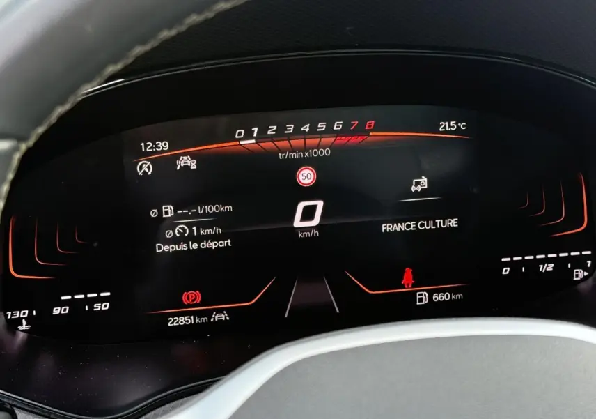 Vue rapprochée du combiné d'instruments digital de la SEAT Arona TSI 115 Style, affichage noir avec détails rouges et blancs.