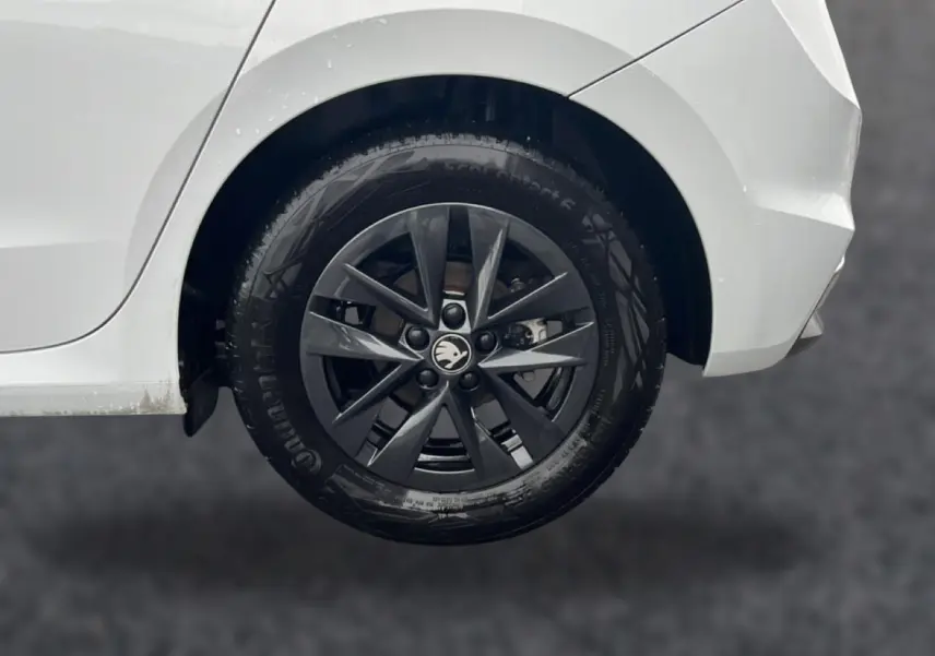 Gros plan sur la roue arrière droite noire avec jante alu d’une Skoda Fabia blanche de 2025.
