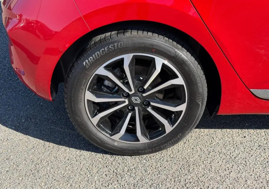Gros plan sur la roue arrière droite orange de la Renault Clio 2025 avec jante alliage noire et argentée.