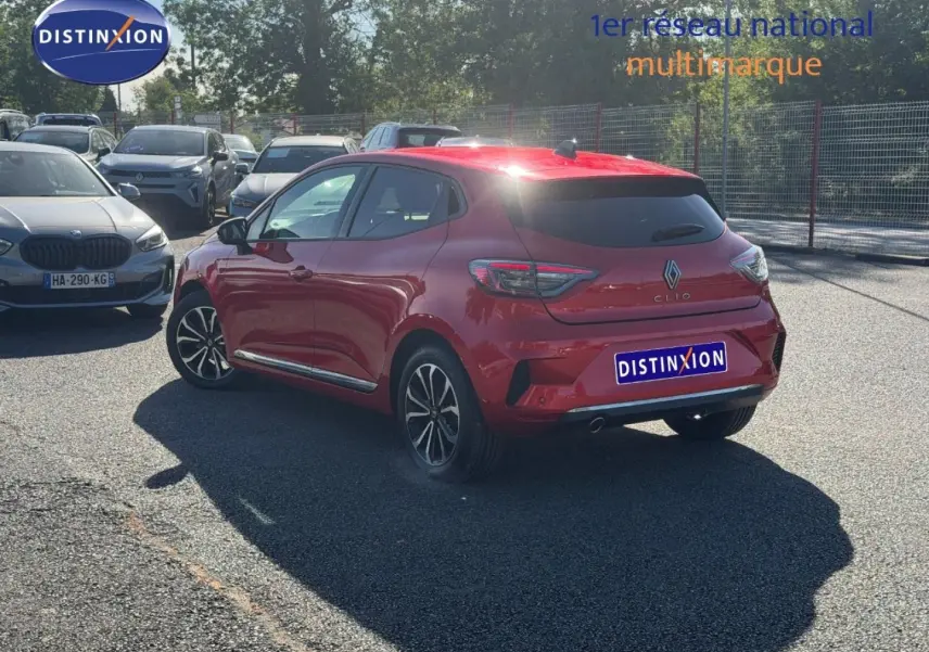 Vue 3/4 arrière droite d'une Renault Clio orange Valencia avec jantes alu et vitres arrière surteintées.