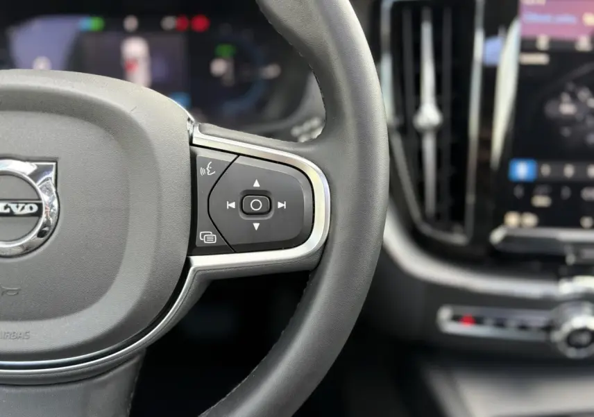 Gros plan sur le volant simili-cuir et les commandes multifonctions du Volvo XC60 T6 AWD PHEV 2024.