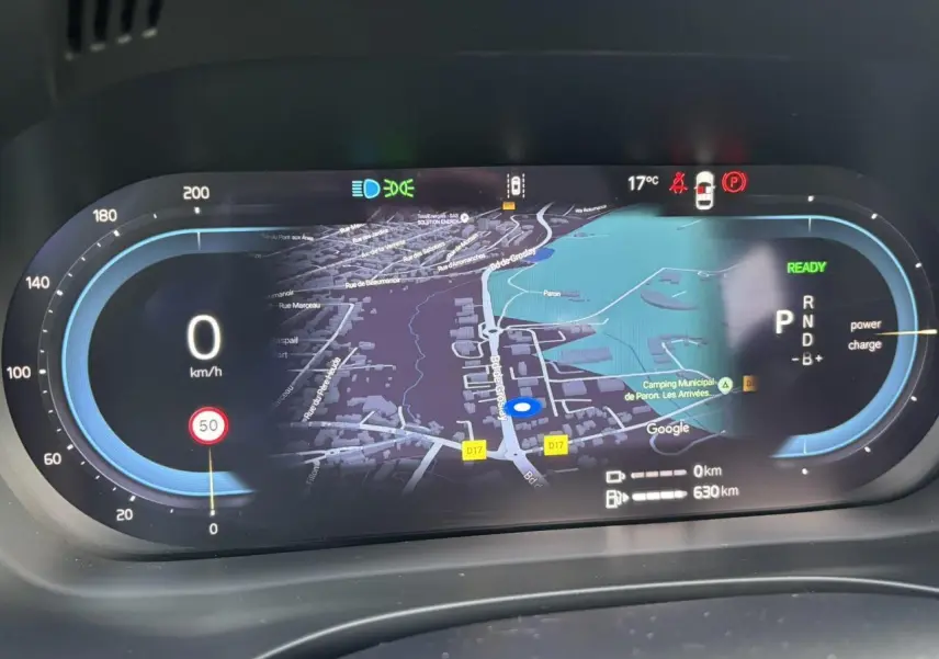 Affichage numérique du tableau de bord du Volvo XC60 2024 avec navigation cartographique et indicateurs de vitesse et énergie.