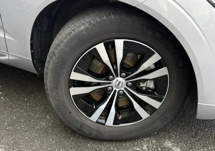 Gros plan sur la jante alliage 18 pouces bicolore du côté avant gauche du Volvo XC60 gris silver 2024.