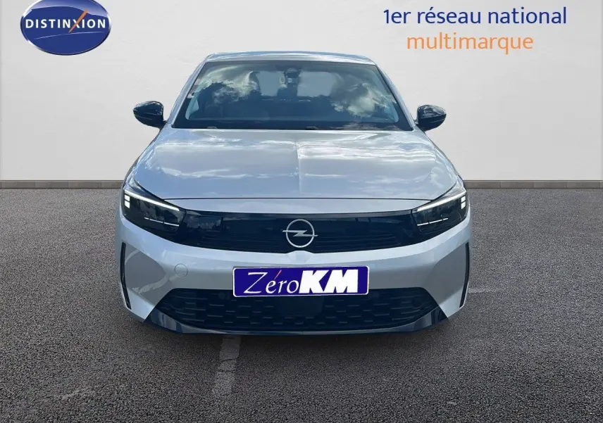 Vue frontale d'une Opel Corsa 2025 gris kristal metal avec calandre noire et phares LED allumés.