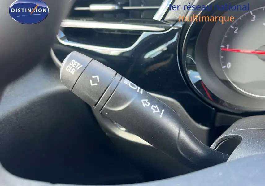 Gros plan sur la manette de clignotant à gauche du tableau de bord d'une Opel Corsa gris kristal métal 2025.