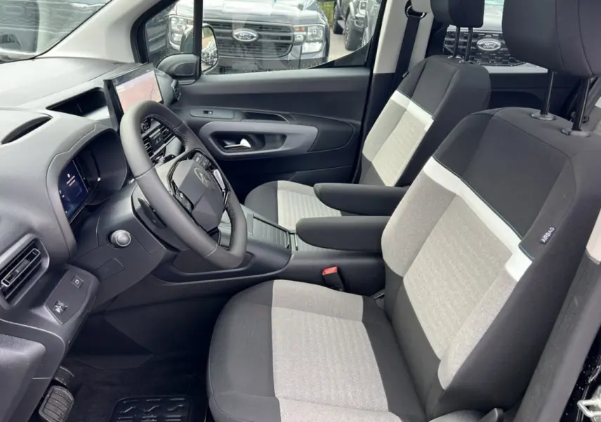Vue intérieure côté conducteur du Citroën Berlingo 2025 noir perla nera, sièges bicolores et tableau de bord moderne.