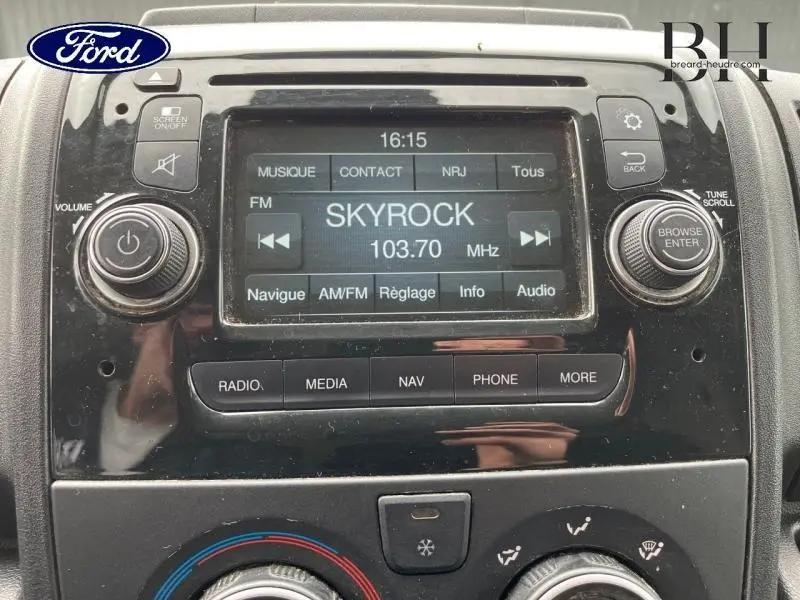 Gros plan sur l'écran tactile central du tableau de bord d'un Citroën Jumper blanc, affichant la radio Skyrock 103.7 MHz.