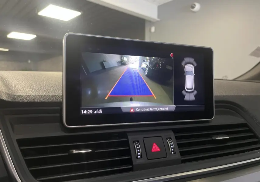 Écran central de l'Audi Q5 S line 2019 montrant la caméra de recul avec guidage de trajectoire en intérieur noir.