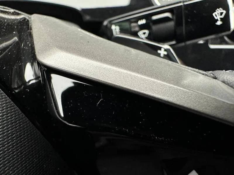 Gros plan sur la commande de régulateur de vitesse dans l'habitacle noir du Peugeot 3008 Hybrid 2025.