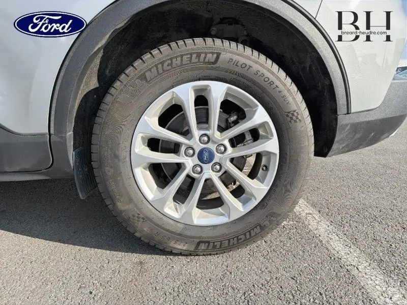 Gros plan sur la roue avant gauche d’un Ford Kuga gris Solar Métallisée avec jante alu et pneu Michelin Pilot Sport.