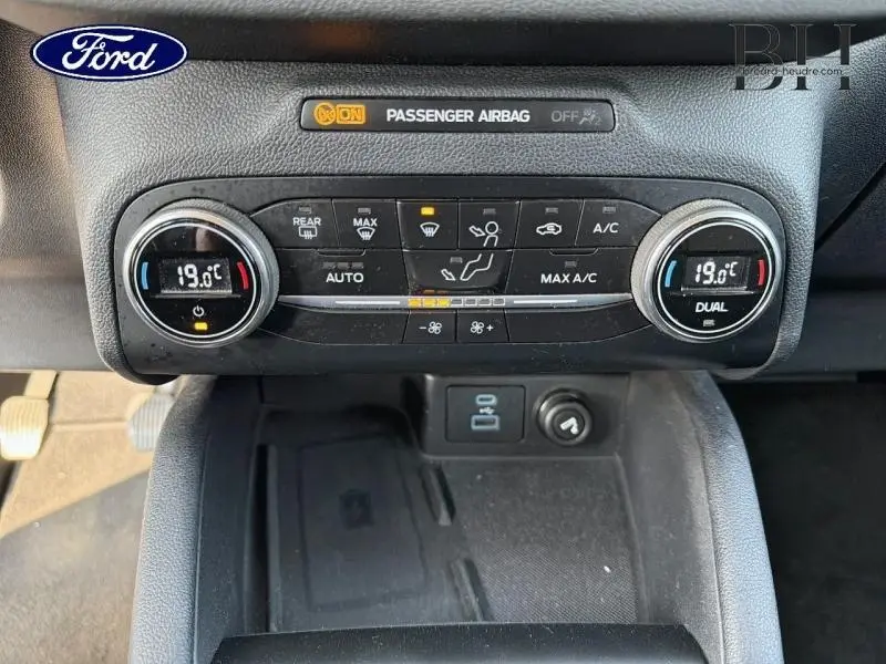 Vue rapprochée de la console centrale du Ford Kuga 2020, montrant la climatisation bi-zone à 19°C.