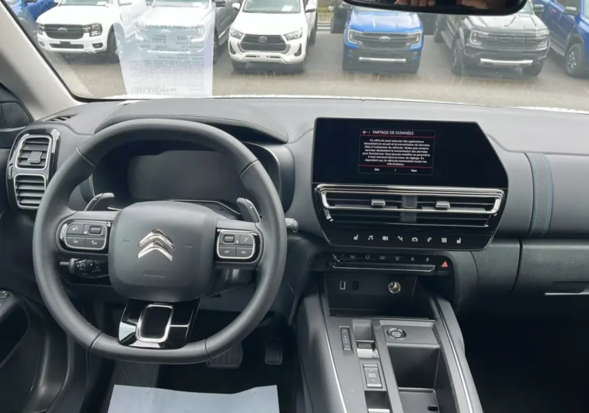 Vue intérieure du tableau de bord et volant cuir multifonctions de la Citroën C5 Aircross blanc okénite 2025.