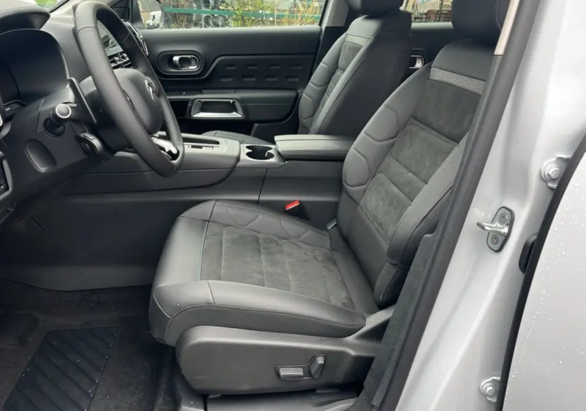 Vue intérieure côté conducteur du Citroën C5 Aircross blanc, sièges en cuir et alcantara avec console centrale visible.