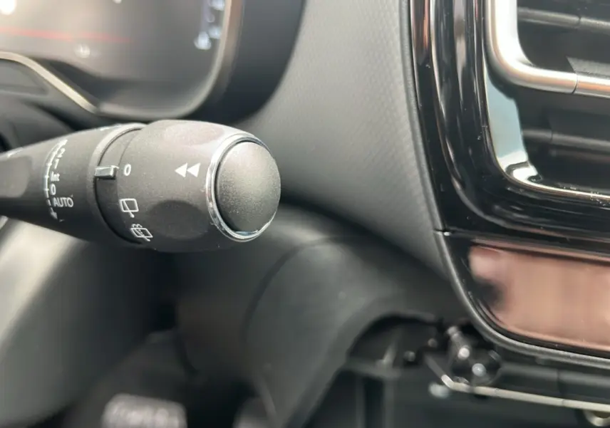 Gros plan sur la commande d’essuie-glace à gauche du volant dans l’habitacle noir du Citroën C5 Aircross 2025.