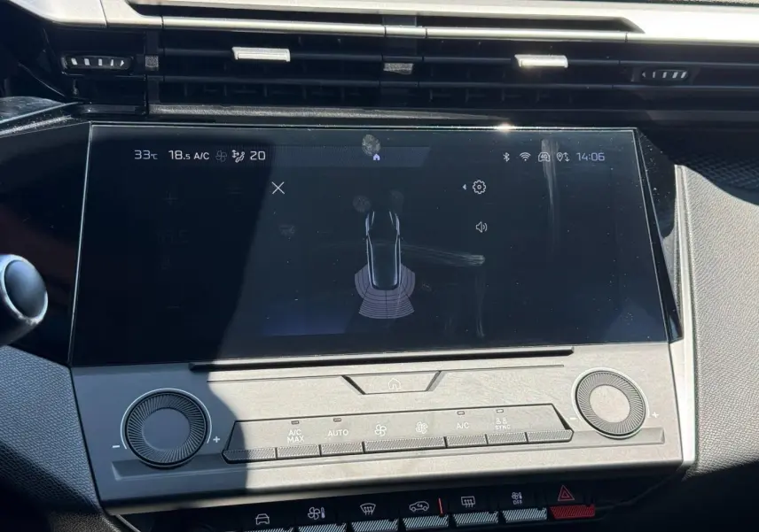 Vue rapprochée de l’écran tactile central de la Peugeot e-308 2025 avec commandes climatisation et interface multimédia.