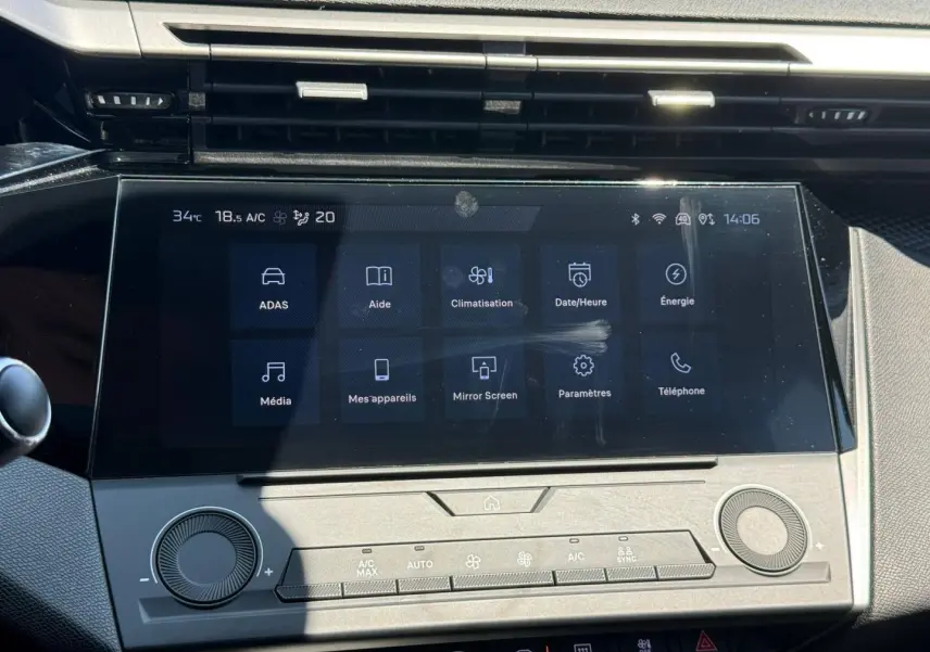 Écran tactile central de la Peugeot e-308 2025 en vue frontale, avec commandes climatisation et interface multimédia.
