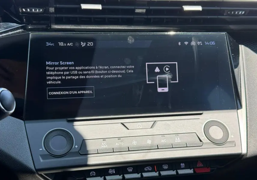 Vue rapprochée de l’écran tactile central de la Peugeot e-308 2025 noir Perla Nera avec commandes climatisation intégrées.