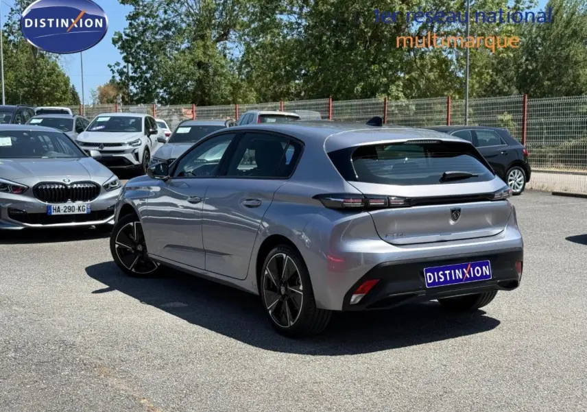 Peugeot 308 e-308 noir Perla Nera vue 3/4 arrière droit sur parking avec jantes alu noires.