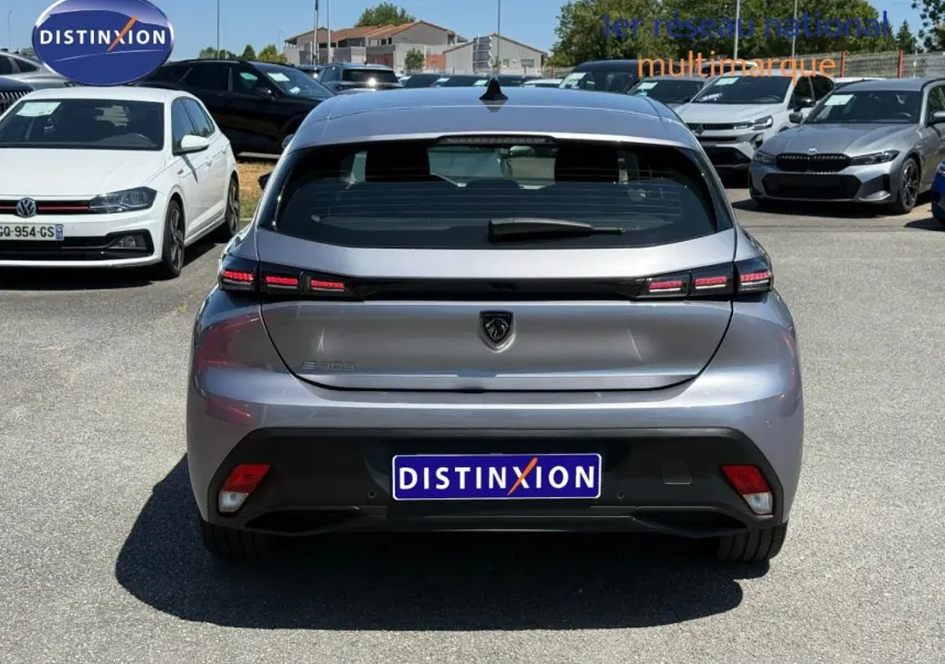 Vue arrière d'une Peugeot e-308 noire Perla Nera avec feux LED distinctifs et logo lion central.